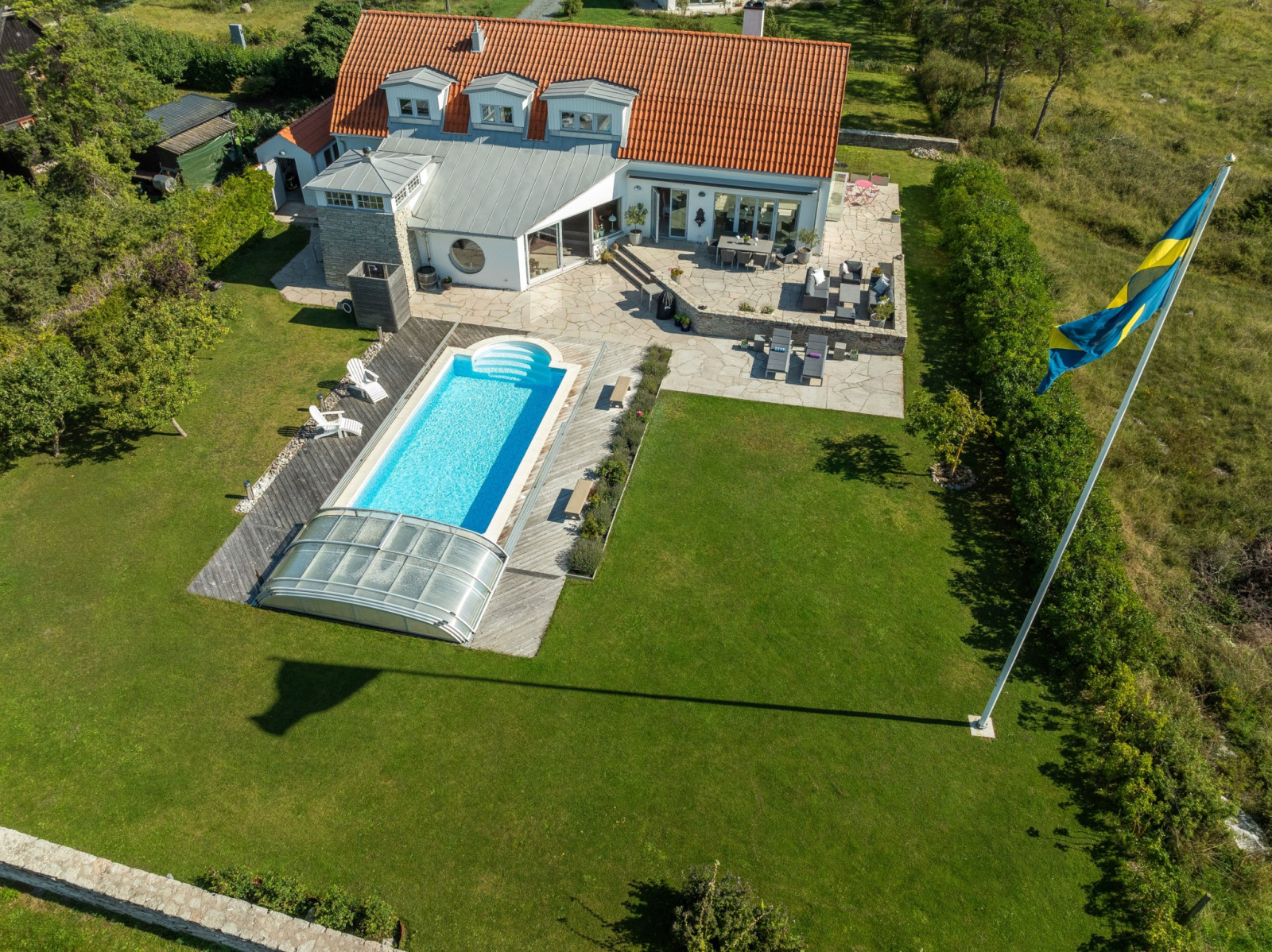 Havsstigen 12 från ovan. Med lättskött tomt , stort poolområde och generösa stensatta terrasser. Sanda Havsstigen 12