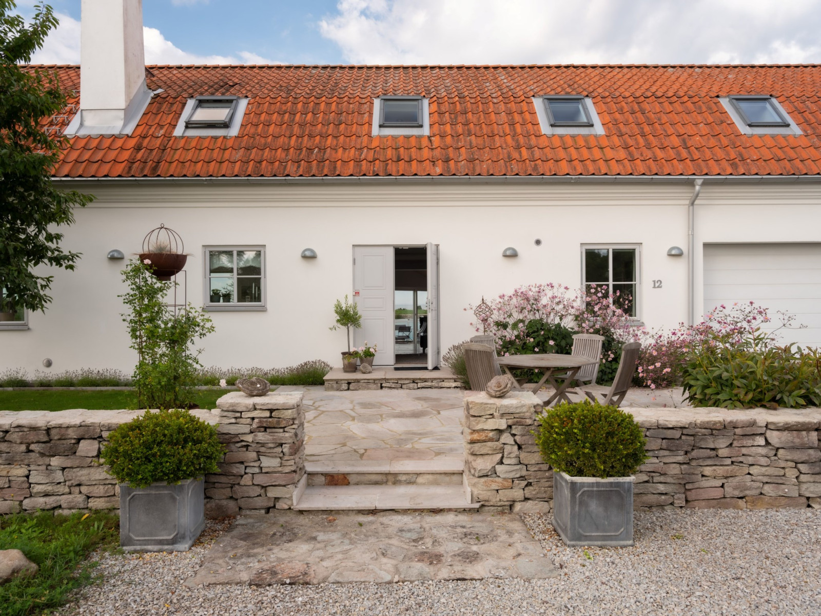 Välkomnande entré med kalkstensterrrass. Sanda Havsstigen 12