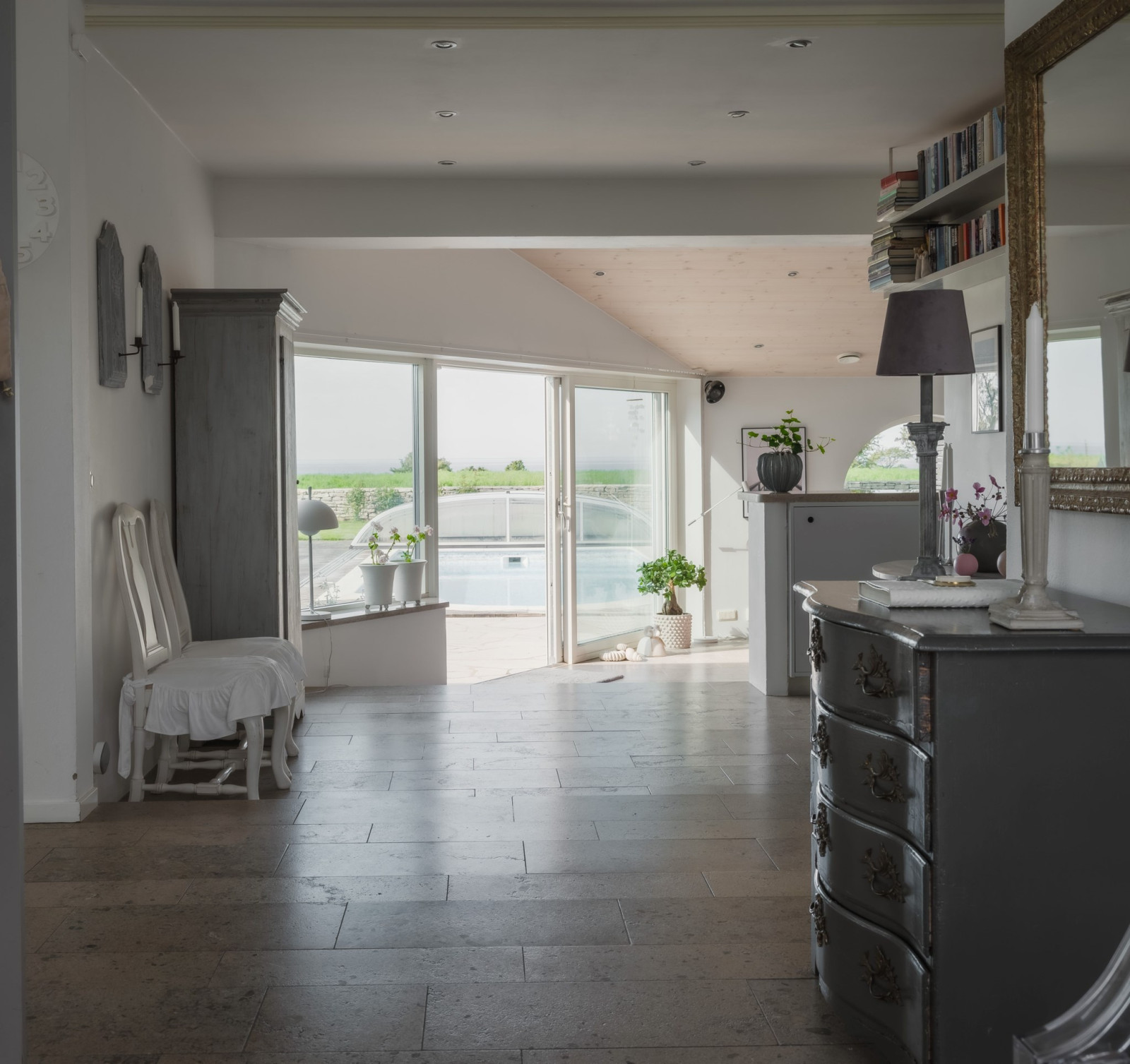 Vy från hallen ner mot relax/TVrum  och utgång till och pool. Sanda Havsstigen 12