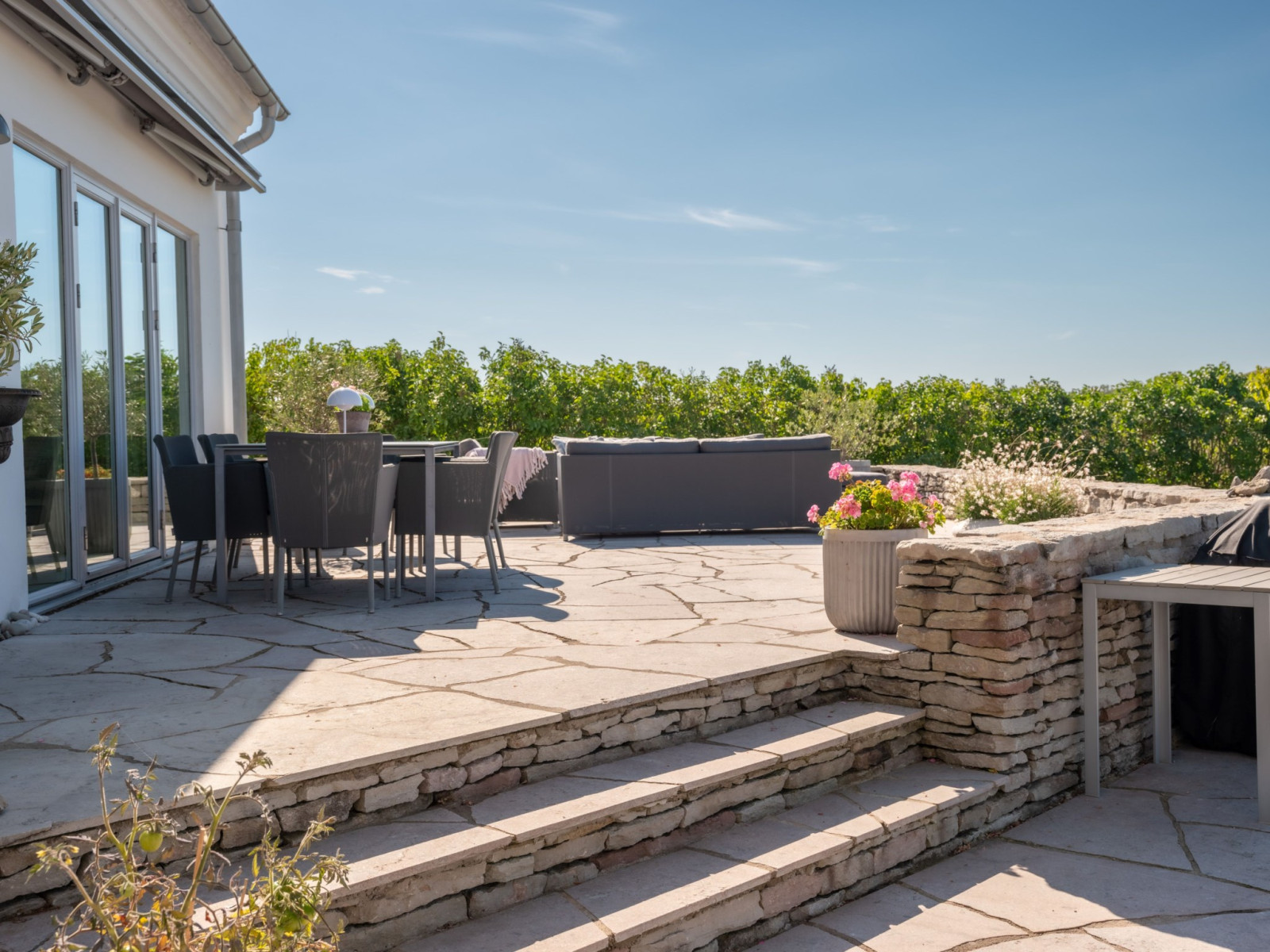 Del av uteplatsen sedd från poolområdet. Sanda Havsstigen 12