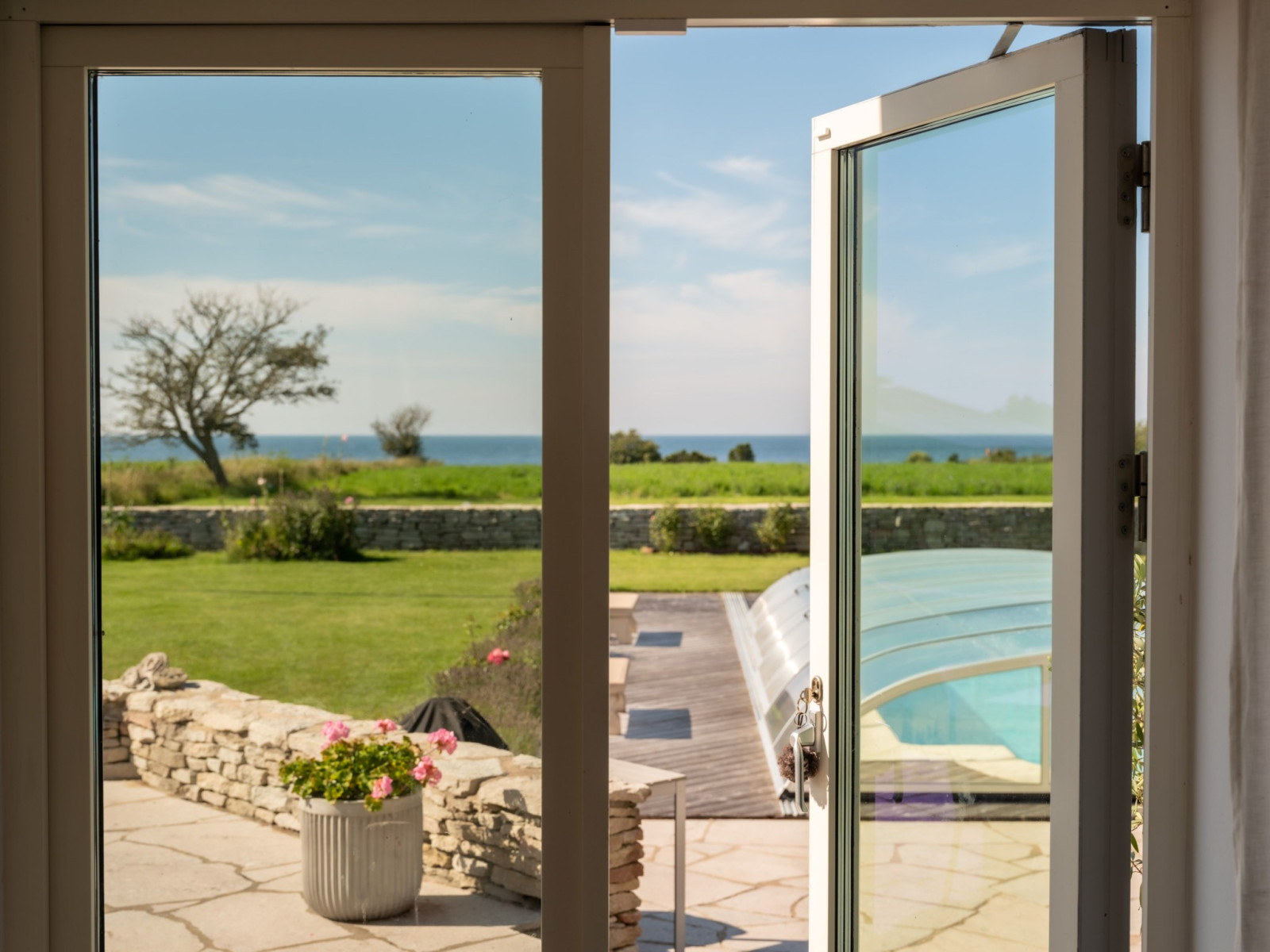 En av många utgångar till tomt, uteplatser och pool. Sanda Havsstigen 12